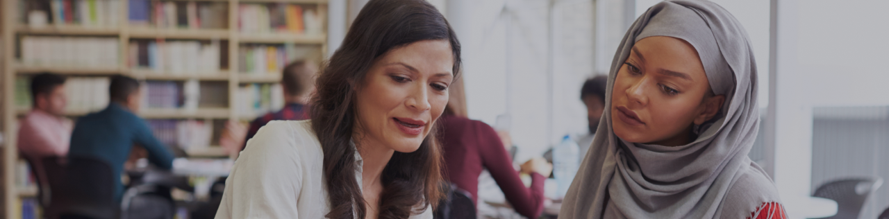 deux femmes regardant quelque chose à la bibliothèque